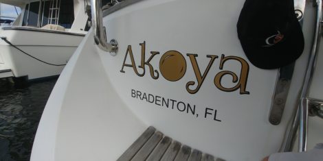 Custom gold vinyl boat name installed on sugar scoop sailboat at Twin Dolphin Marina in Bradenton FL
